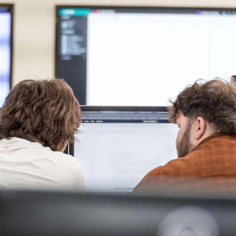 A pair of IT Services C5 Team Members working at their desks in C5 Operations centre
