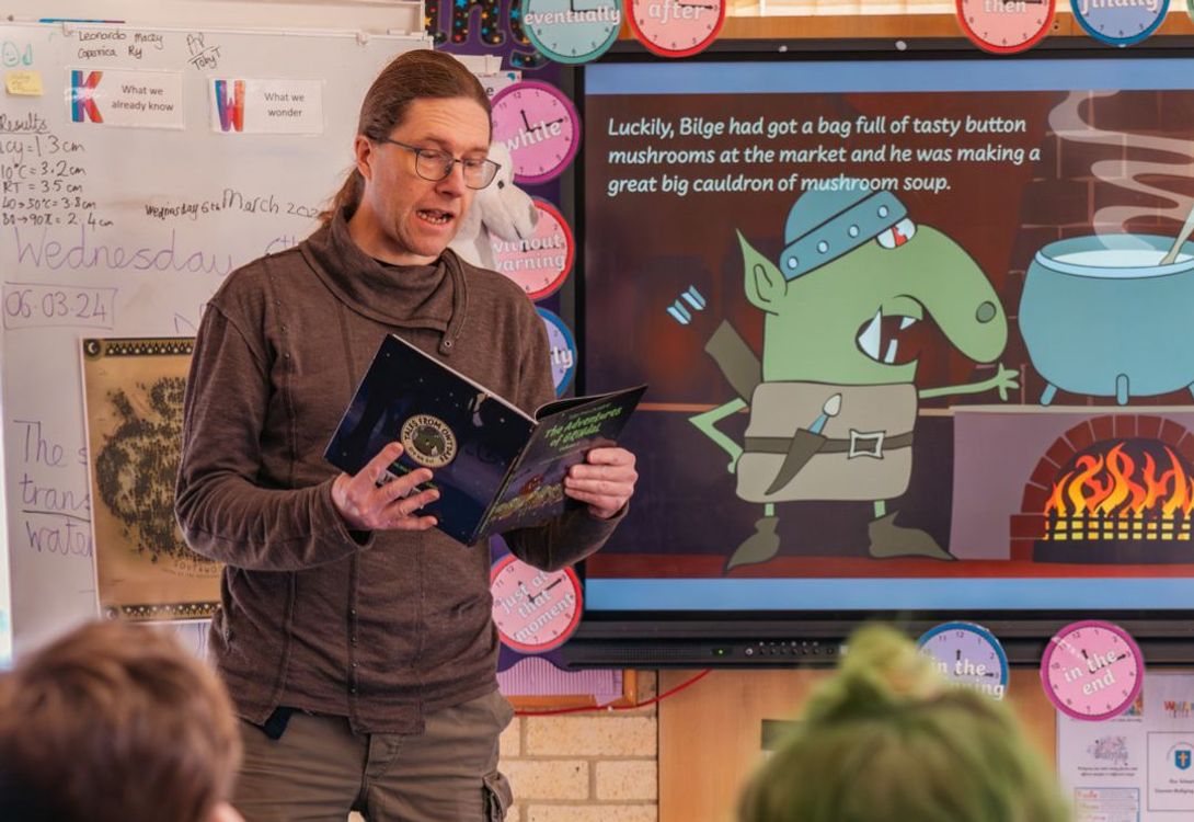 A C5 Team Member leading a book reading session in a primary school classroom