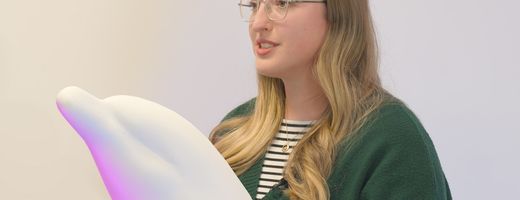 An artist next to the sculpture of a dolphin that they will be decorating for the Guernsey Dolphin Trail 2025