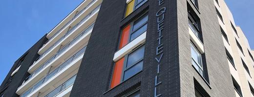 A photo of a block of flats in St Helier jersey looking upwards and the newly restored building from a low angle