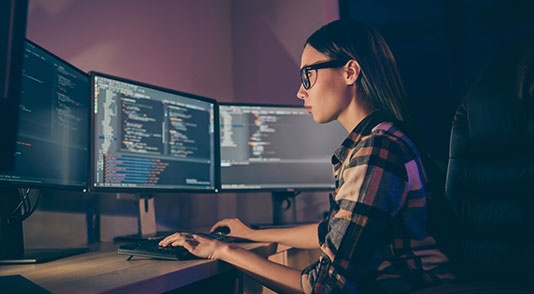 An applications developer sitting at a computer workstation